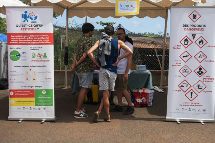 People gathered around information banners at an outdoor event.